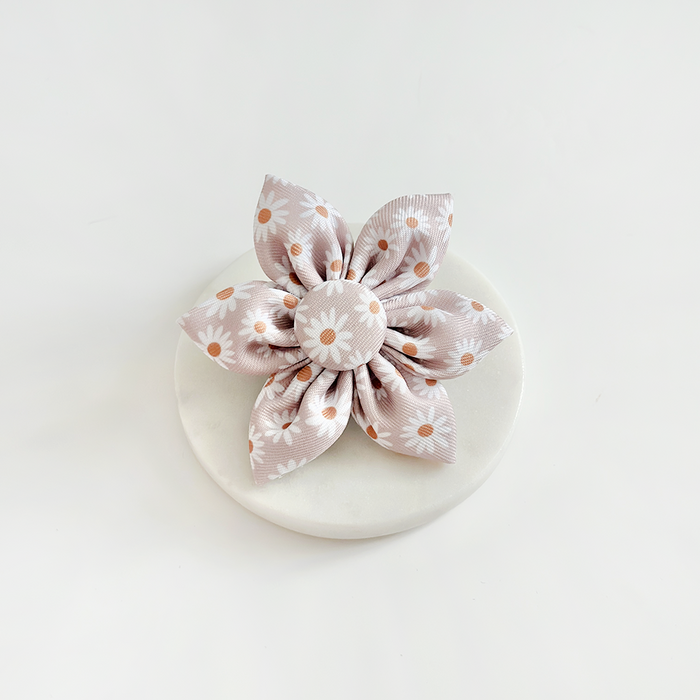 Mauve and white daisy-shaped pet collar accessory with orange polka dots.