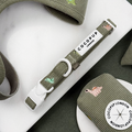 Green corduroy material Dog Collar with embroidered dinosaurs. White D Ring attachment.