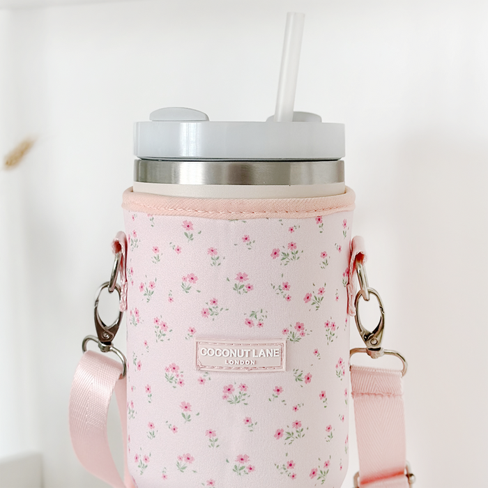 Stainless steel tumbler with straw in a pink floral carry case with shoulder strap.