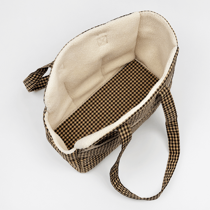 Showing the inside of a brown check print Dog Carrier with a cream sherpa fleece lining. Reversible base plate.