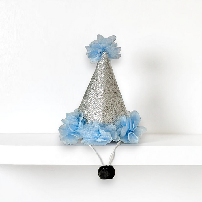 Blue dog party hat with silver glitter, blue fabric flowers, and a black pom-pom on top.