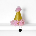Pink dog party hat from Cocopup London with glittery details and pink flower accents.