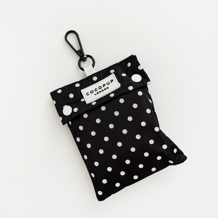 Black polka dot dog raincoat with matching pouch, both featuring a bold dot pattern.