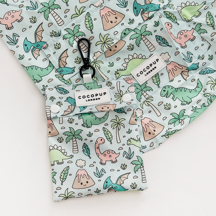 Light blue dog raincoat with colorful dinosaur print, matching shirt, and coordinating pouch.
