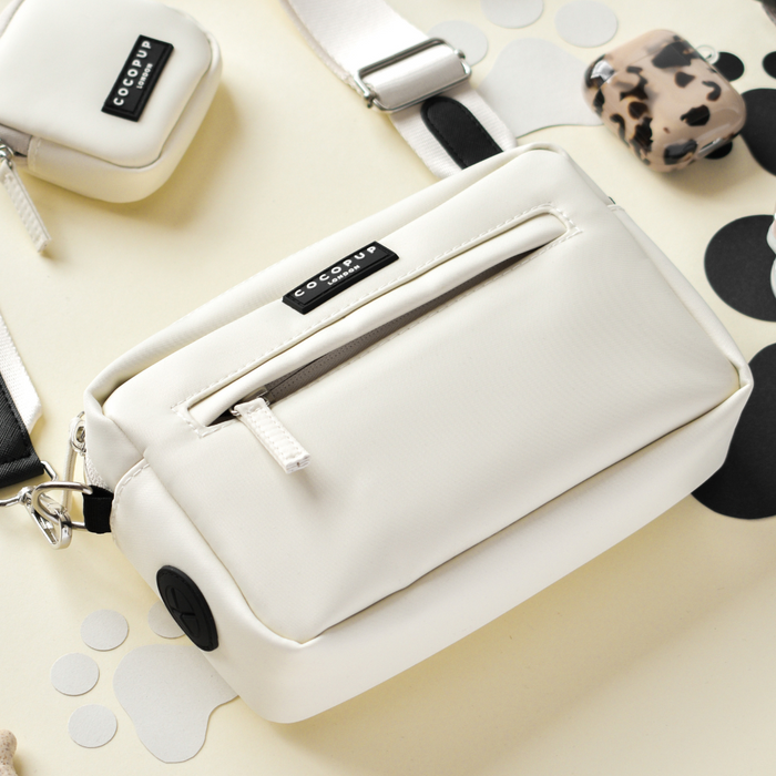 Oyster white Cocopup London dog walking bag with front zipper and black-and-white strap.