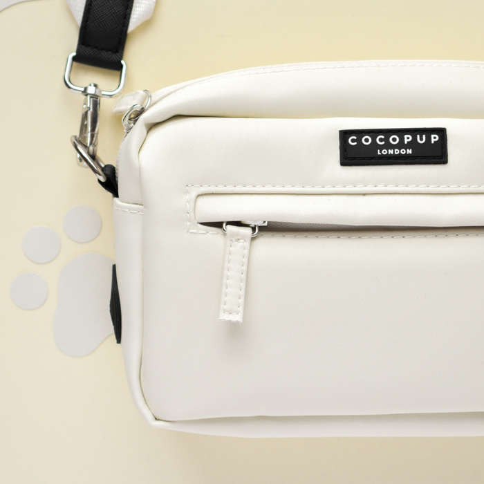 Oyster white Cocopup London dog walking bag with front zipper, water-resistant fabric, and built-in poop bag dispenser.