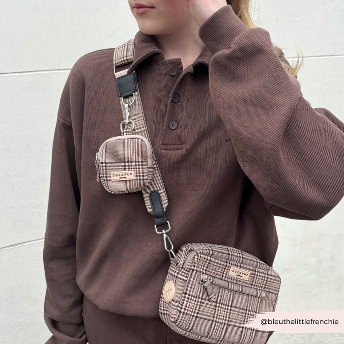 Person in a brown shirt wears a plaid Cocopup London dog walking bag with wide strap and matching treat pouch.