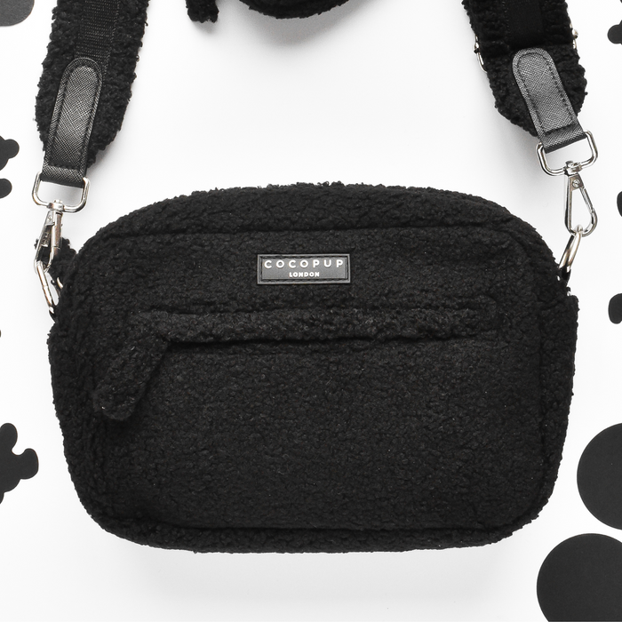 Black teddy fabric dog walking bag with white polka dots and built-in poop bag dispenser.