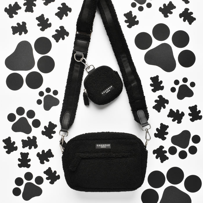 White Cocopup London dog walking bag with small pouch, poop bag dispenser, and black paw and bone print pattern.