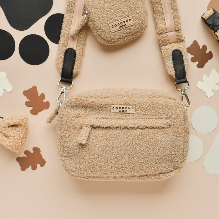 Beige fleece dog walking bag by Cocopup London with paw and bone-shaped cutouts.