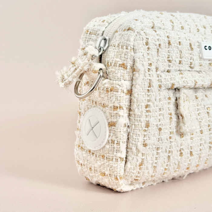 Cocopup London dog walking bag in vanilla textured tweed with gold zipper and round white side button, close-up view.