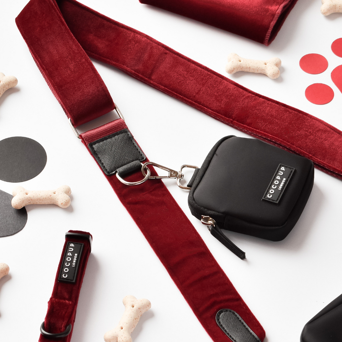 Berry red velvet dog walking bag set with matching strap, treat pouch, collar, and bone-shaped accessories on white background.