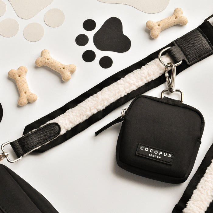 Black Cocopup London dog walking bag bundle with matching leash, treat pouch, and bone treats on a white surface.