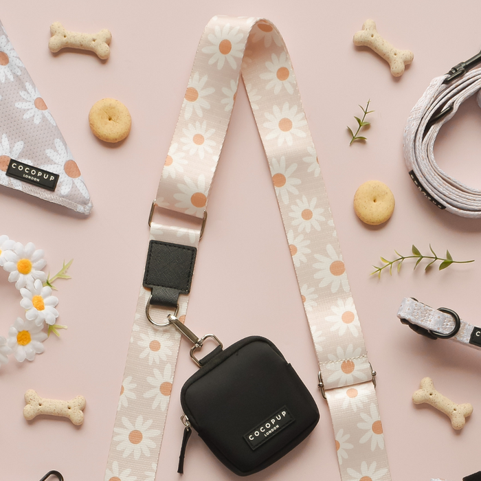 Cocopup London Daisy Chain dog walking bag bundle with treat pouch, bandana, lead, and collar on a pink background.