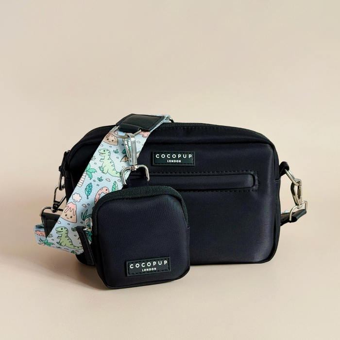 Dinopaws-patterned dog walking bag with treat pouch and matching strap, displayed on a beige background.