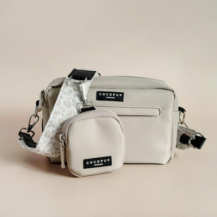 Two Cocopup London Luxe dog walking bags in Garden Meadow print with black labels and patterned straps on a neutral backdrop.