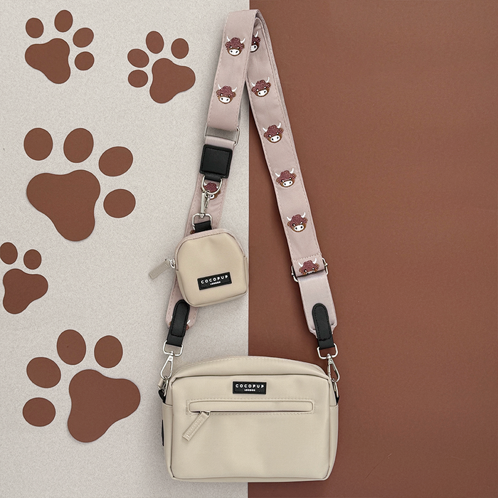 Beige crossbody dog walking bag bundle with Highland cow motif, matching treat pouch, and poop bag holder.