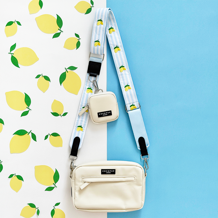 Cream crossbody dog walking bag with matching treat pouch and a strap featuring a lemon print.