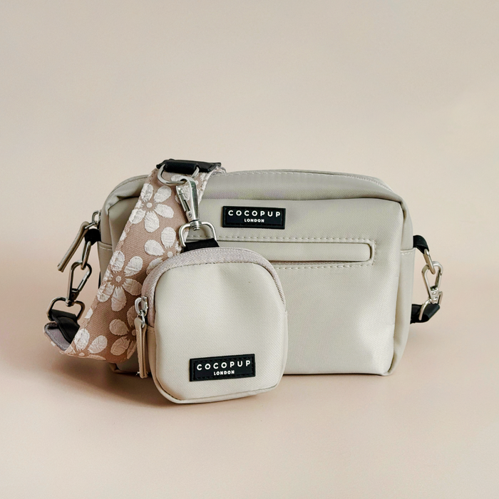 Two mocha-colored Cocopup London dog walking bags with floral patterns, each with a zip closure and detachable strap.