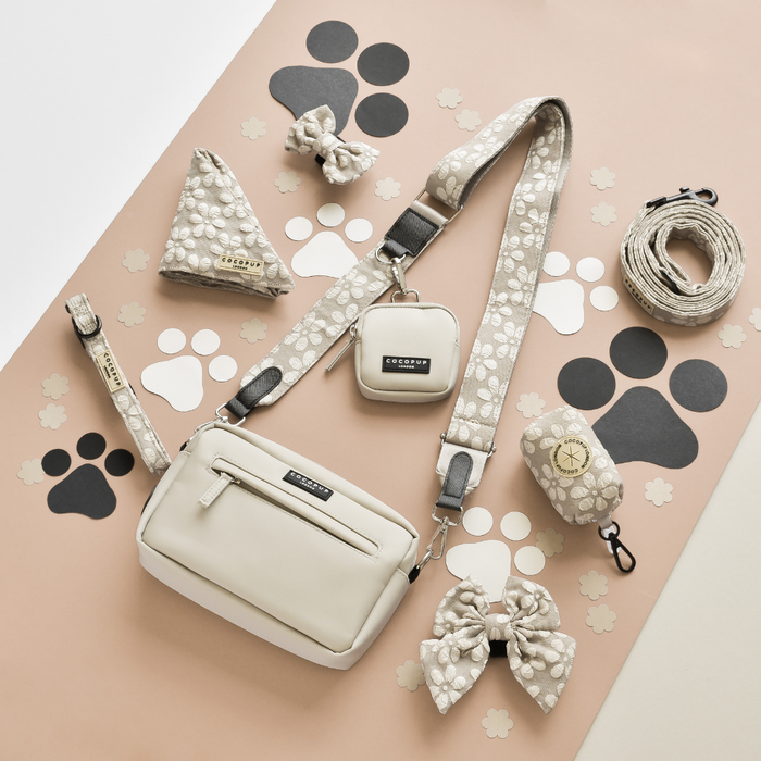 Mocha Flower dog walking bag set with matching leash, bow ties, and treat pouch on a paw print background.