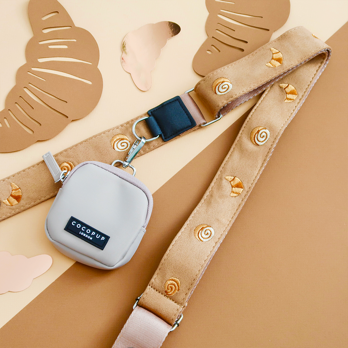 Cocopup London dog walking bag with beige strap, croissant pattern, and matching treat pouch.