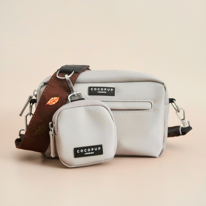 Two Cocopup London dog walking bags, brown with leaf-patterned detachable straps and black labels.
