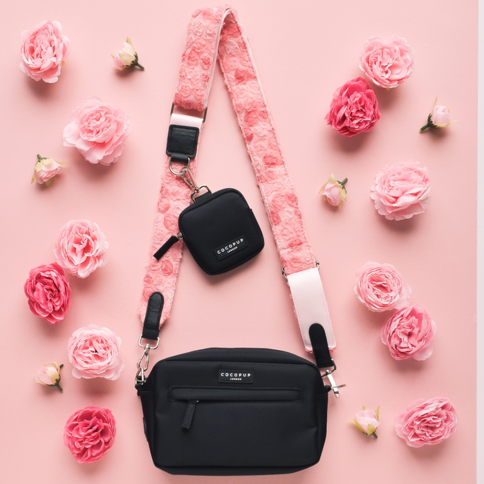 Black crossbody dog walking bag with pink floral strap, matching treat pouch, and bag dispenser.