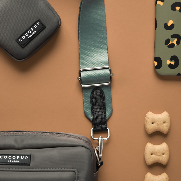 Khaki Cocopup London dog walking bag, small treat pouch, and animal print phone case on a brown background.