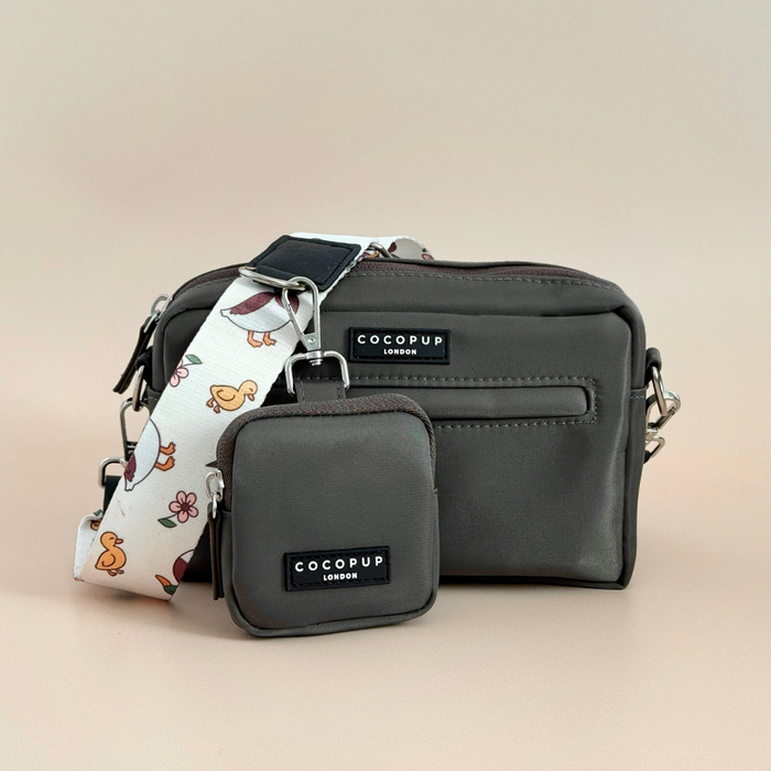 Beige Cocopup London dog walking bag with a small treat pouch and white duck-patterned strap on a beige background.