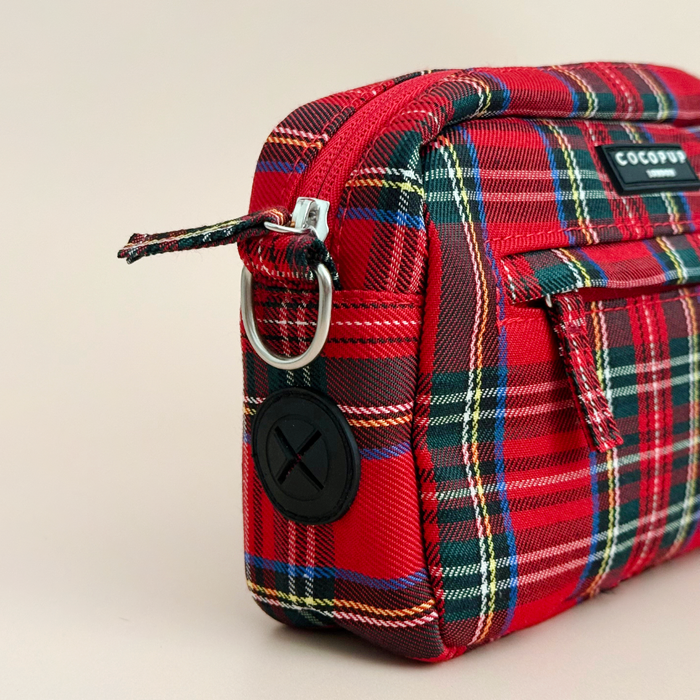 Tartan-patterned Cocopup London dog walking bag with zip pouch, front pocket, and black circular logo patch.