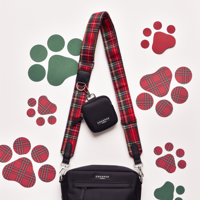 Black dog walking bag with red tartan strap, matching treat pouch, and green and red paw print details.