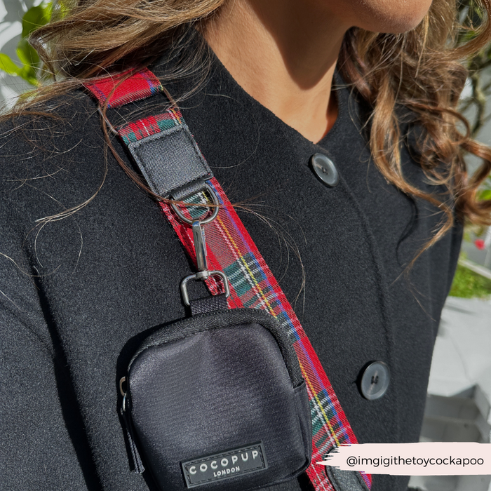 Cocopup London tartan dog walking bag with a red tartan strap worn over someones shoulder.