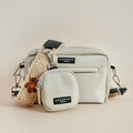 Beige Cocopup London crossbody dog walking bag with embroidered teddy, treat pouch, and attached poop bag dispenser.
