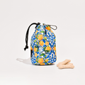 Yellow Cocopup London drawstring treat pouch with Amalfi lemon print, next to three bone-shaped biscuits on white background.