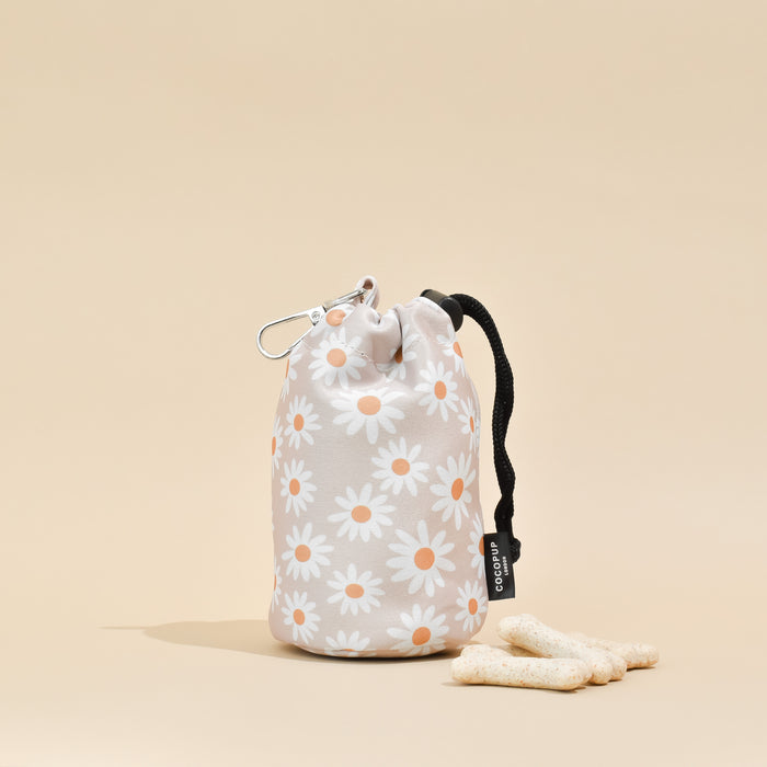Daisy Chain drawstring treat pouch by Cocopup London with three treats on a beige background.