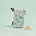 Cocopup London drawstring treat pouch with a green dino print and bone treats on a light green background.