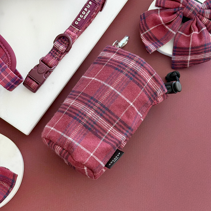 Mulberry plaid drawstring treat pouch with matching dog bow tie, collar, and waste bag holder displayed together.