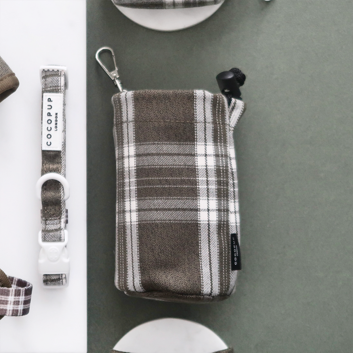 Olive check Cocopup London drawstring treat pouch and dog leash set on a gray and white surface.