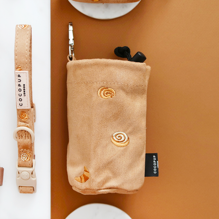 Tan suede treat pouch with a drawstring and cinnamon roll embroidery on the front.
