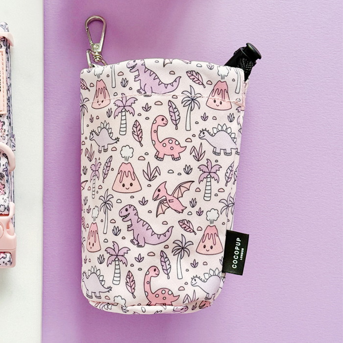 Pink and purple Cocopup London treat pouch with a cute dinosaur pattern and drawstring closure.