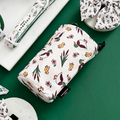 Cocopup London drawstring treat pouch in Puddle Pup pattern on green surface beside a dog collar.