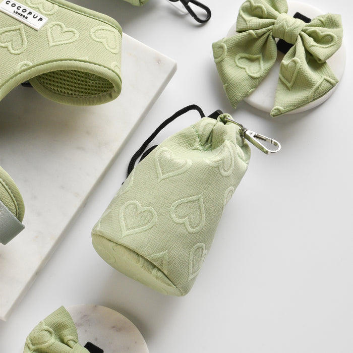 Sage green waterproof dog treat pouch with a drawstring closure and embossed heart pattern.