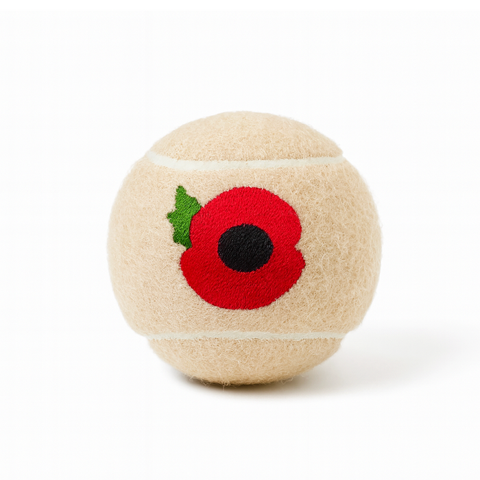 Beige dog tennis ball with a red poppy flower embroidered on one side.