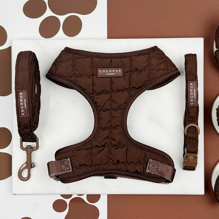 Espresso brown quilted harness, lead, and collar set from Cocopup London on a paw-print background.