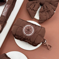 Espresso brown quilted poop bag holder with matching dog walk accessories on a beige and brown background.