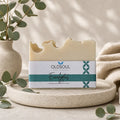 Bar of soap with 'Oldsoul' label on a stone surface with greenery