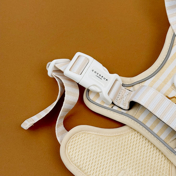 Close up of Dog Harness buckle, pale yellow and white striped Dog Harness with embroidered honeycomb and bees, featuring Cocopup Explore logo.