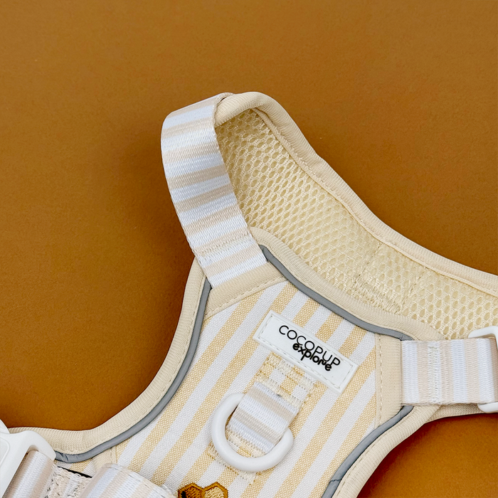 Close up of Dog Harness, pale yellow and white striped Dog Harness with embroidered honeycomb and bees, featuring Cocopup Explore logo.