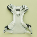 Sage Tweed Explore Harness by Cocopup London in light grey with black buckles on a pale green background.