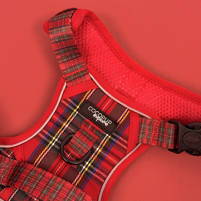 Red tartan Cocopup London Explore Harness with black buckle and mesh lining on a red background.